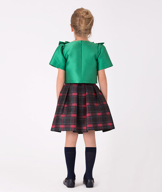 Girls' plaid and green bow outfit for festive occasions – A charming combination of a traditional plaid skirt and eye-catching green metallic bow top, perfect for making a stylish statement