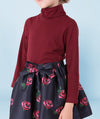 a soft turtleneck burgundy blouse with long sleeves