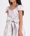 Elegant white and gold printed dress with cap sleeves and waist-tie bow, ideal for girls' formal wear