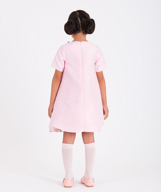 a pink blouse and a matching pink jacquard skirt with feathers