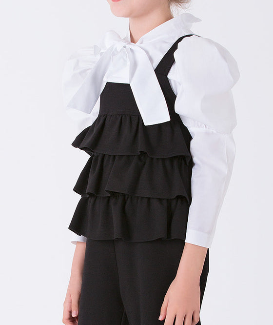 black layered jumper with elegant ecru blouse with a bow on the neckline