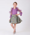 Lilac ruffled blouse and green flared skirt with colorful prints and a bow on the waist