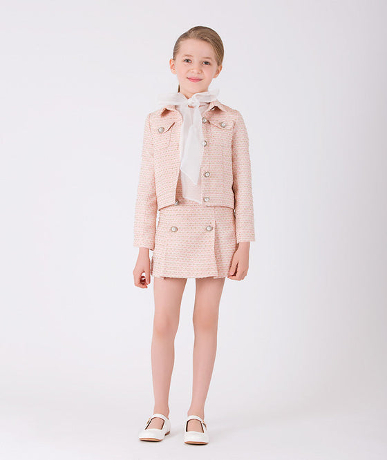 A stylish set of a chic, elegant ecru blouse, pink tweed skirt and matching jacket with elegant buttons
